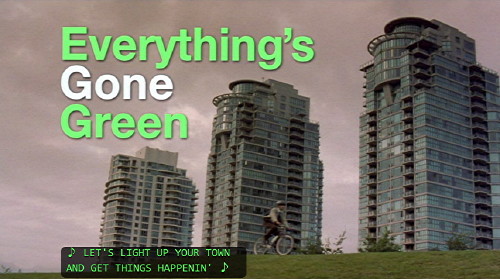 Screenshot shows â€˜Everything’s Gone Green' title in green and white Helvetica type, with Vancouver see-throughs in the background, a bicyclist, and a caption