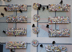 Overhead view of tables covered in tiny-seeming books