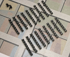 Diagonal ranks of empty black chairs seen from overhead